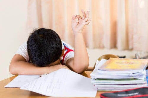 Anemi hos barn: pojke vid skolbänk lutar huvudet mot bänken och håller upp hand