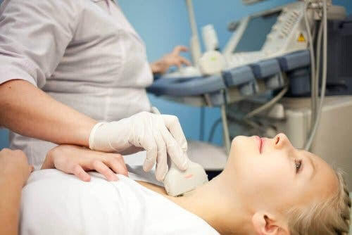 kvinna får ultraljudsundersökning av halsen efter knutor på sköldkörteln