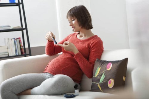 Gravid kvinna sticker sig i fingret för att kolla blodsockernivåerna.