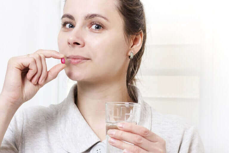 Kvinna tar sockerpiller med vatten.