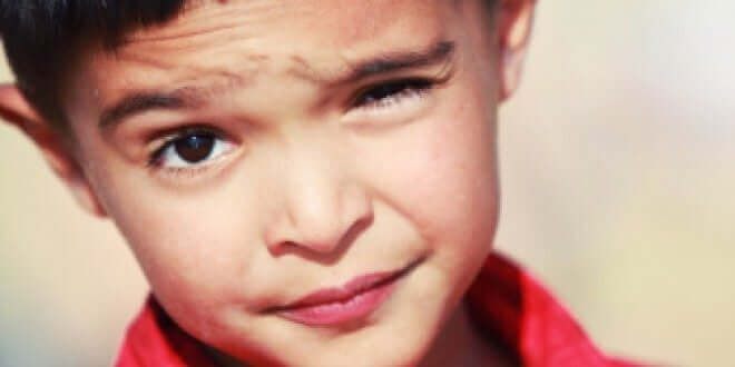 Barn med tics blinkar med ögat.