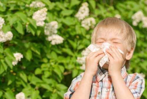 En pojke som har barnastma och nyser i en näsduk.