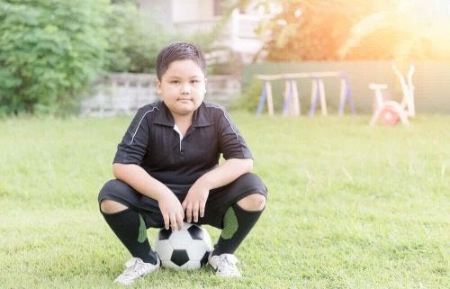 Fysisk inaktivitet hos barn: pojke sitter på fotboll
