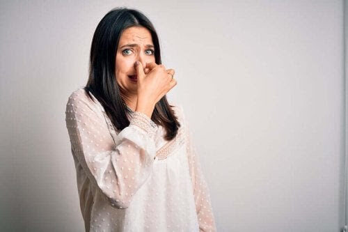 dermatitis neglecta: kvinna håller för näsan