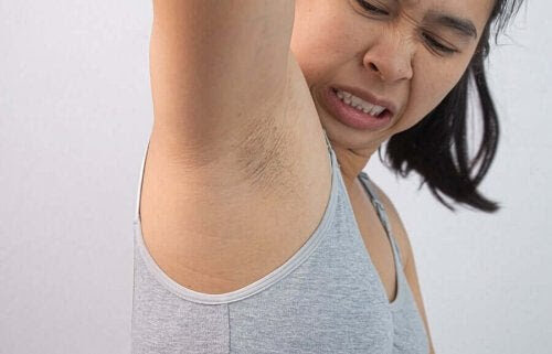 dermatitis neglecta: kvinna rynkar på näsan åt sin armhåla