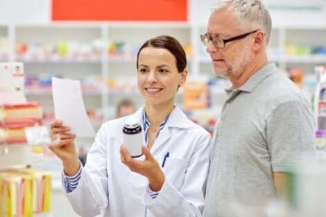 En farmaceut visar vad bipacksedeln innehåller för en kund.