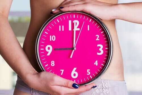 kvinna håller klocka