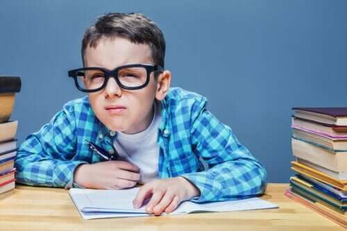 Pojke med glasögon kisar när han läser.