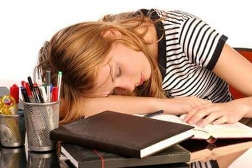 Högt ferritinvärde: En trött kvinna som somnat över sina böcker.