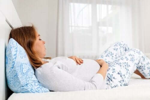 Gravid kvinna ligger i sängen.