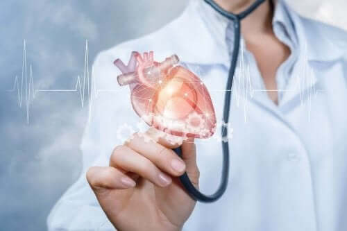 En läkare håller ett hjärta i sin hand.