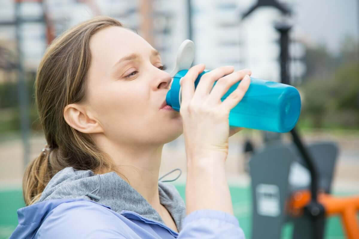 kvinna dricker vatten för att upprätthålla vätske- och elektrolytbalansen