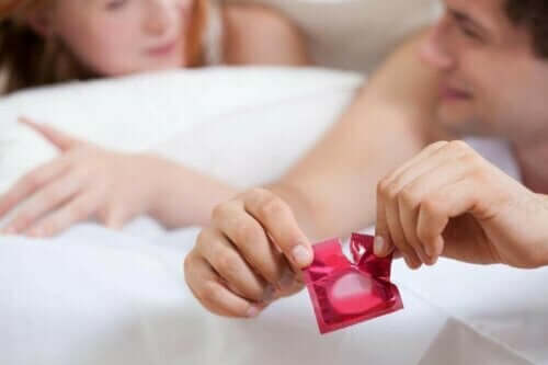 Samband mellan preventivmedel och blodpropp: En man öppnar en kondom.