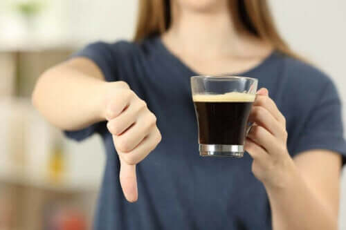 Samband mellan kaffe och hjärtattack: en kvinna ger tummen ner för kaffe.