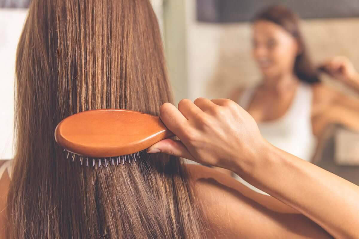 rengör din hårborste: kvinna borstar håret