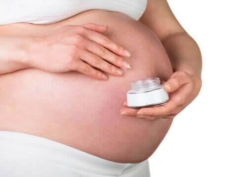 gravid kvinna smörjer in magen