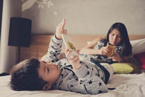 Överdriven exponering för skärmar: litet barn med skärm, mamma på telefon