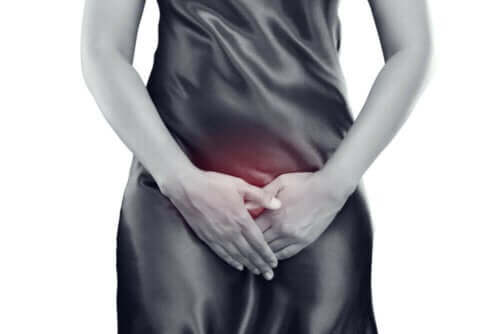 Kvinna med urinvägsinfektion håller sig för framsidan.