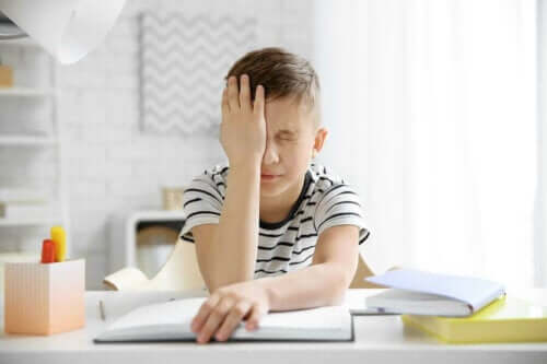Barn med huvudvärk försöker göra hemläxa.