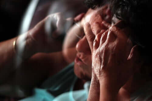 Stressad person håller sig för huvudet.