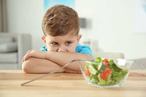 pojke tittar skeptiskt på sallad