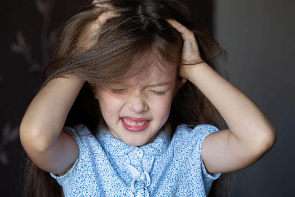 Håravfall hos barn: flicka drar sig i håret