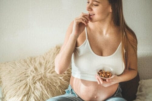 gravida kvinnor äta till middag: gravid kvinna äter nötter