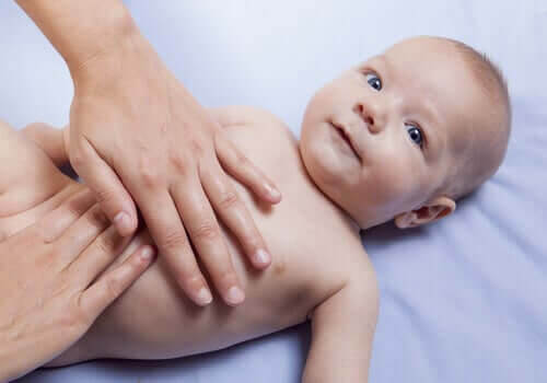 probiotika till spädbarn: läkare undersöker mage på baby