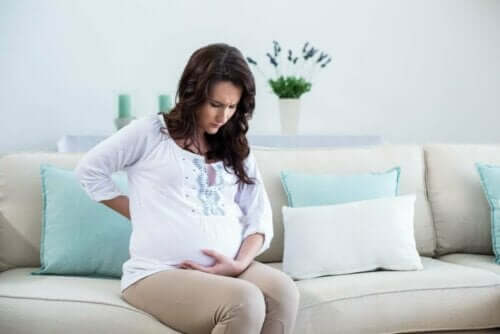 Menstruationskramper under graviditeten: gravid kvinna på soffa