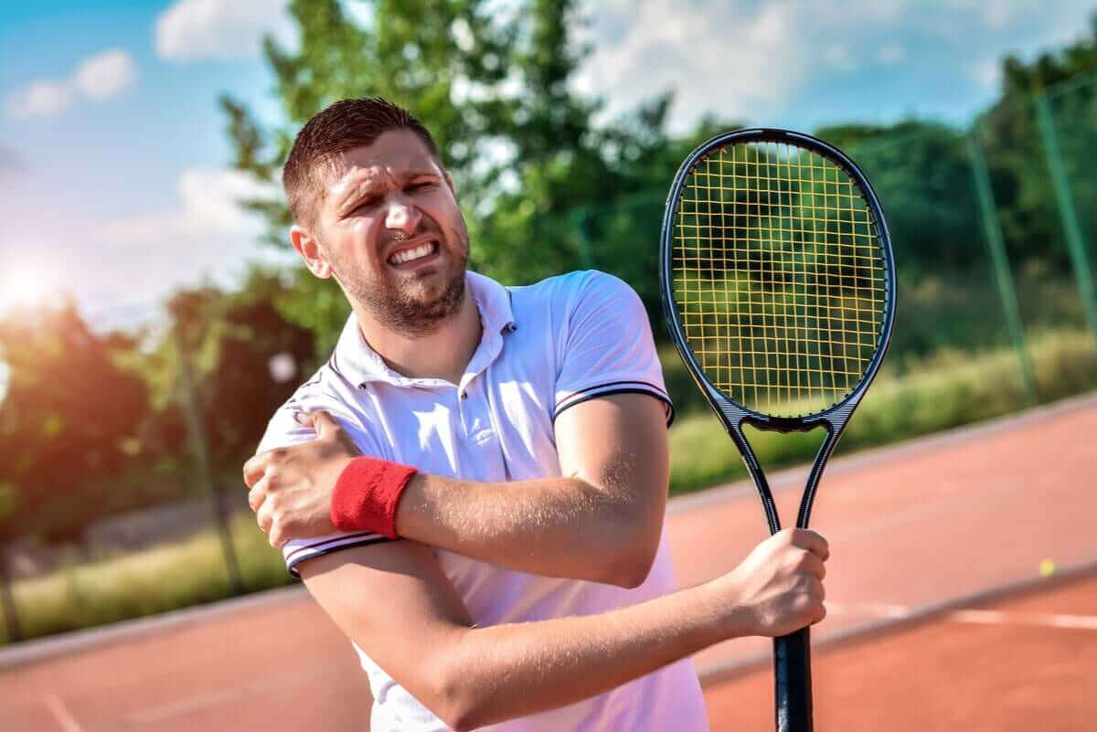man med tennisracket har ont i axeln