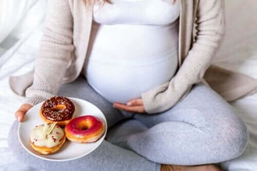 Fetma under graviditeten: gravid kvinna med tallrik med munkar