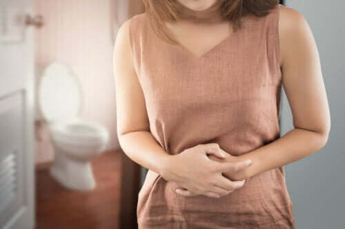 tarmens mikrobiom är skadat: kvinna håller sig för magen