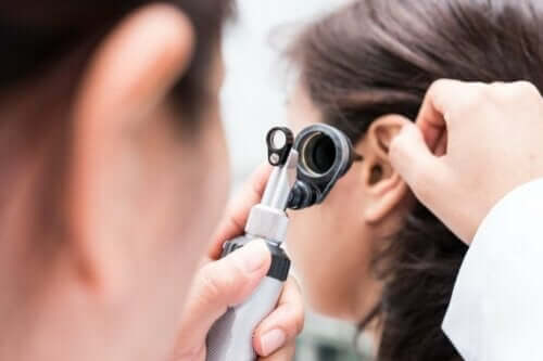behandling av lägesyrsel: läkare undersöker patients öra