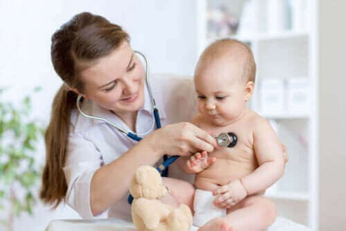 läkare undersöker baby efter Gropar vid korsbenet