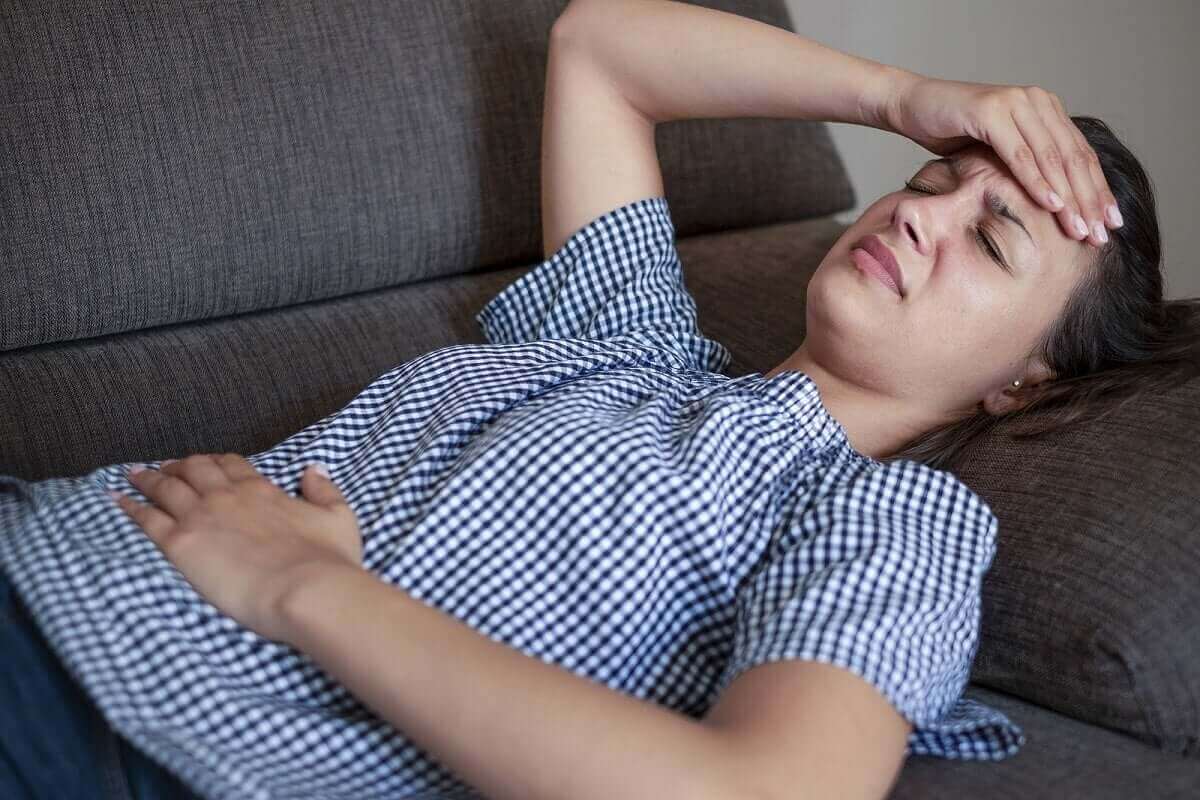 kvinna på soffa ser lidande ut