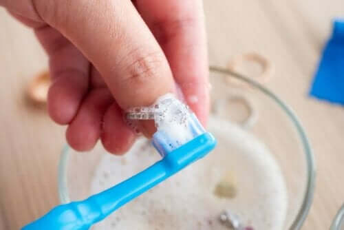 person tvättar sin ring med en tandborste och ätticka.