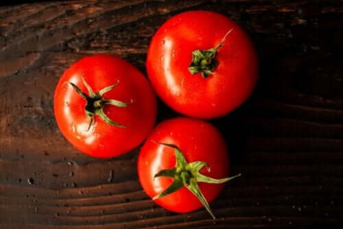 tre röda tomater på ett bord