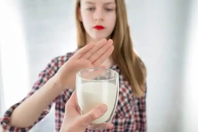 tjej som inte vill ha ett glas med mjölk