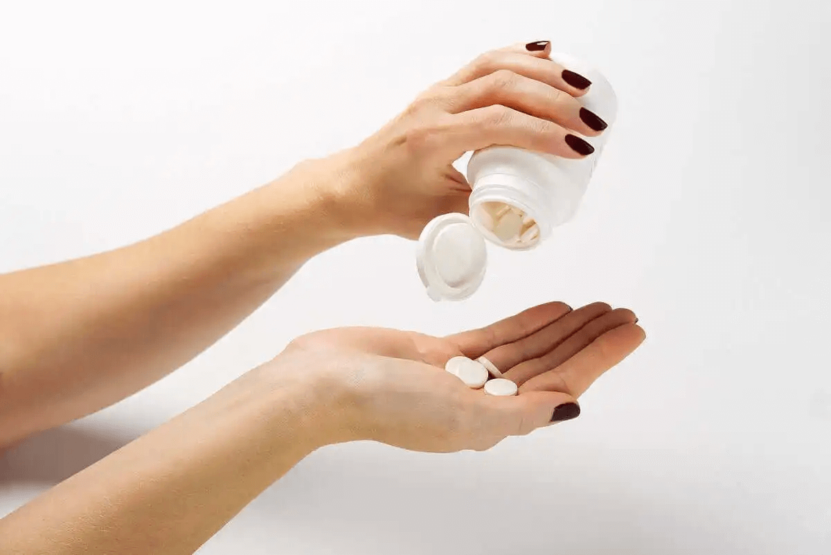 person häller upp piller