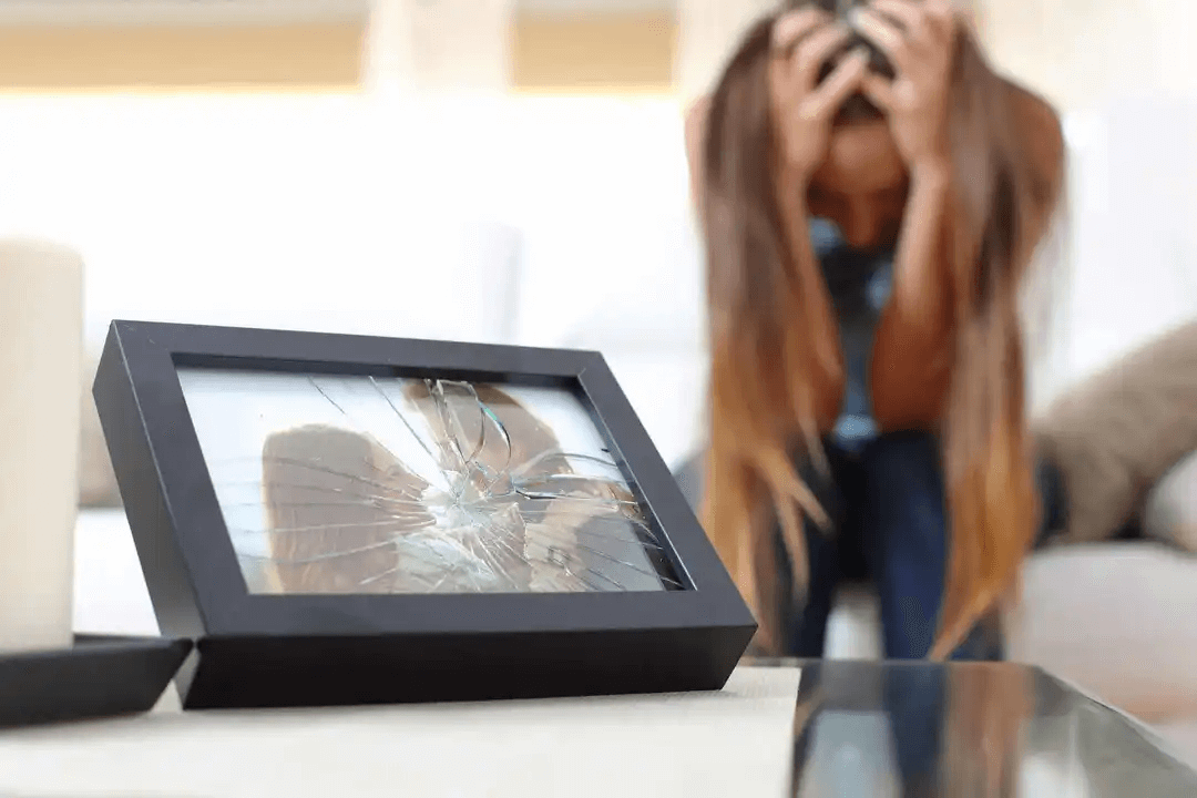 känslomässig distans: ledsen kvinna vid krossat foto