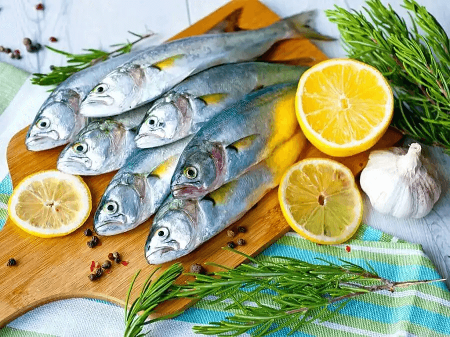 fisk på skärbräda med citron och örter