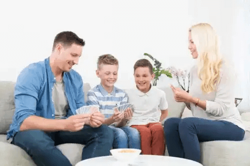 skäl att vara lycklig: familj spelar kort