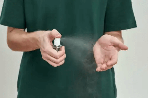 man sprayar handflator