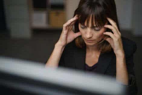 kvinna på jobb med huvudvärk