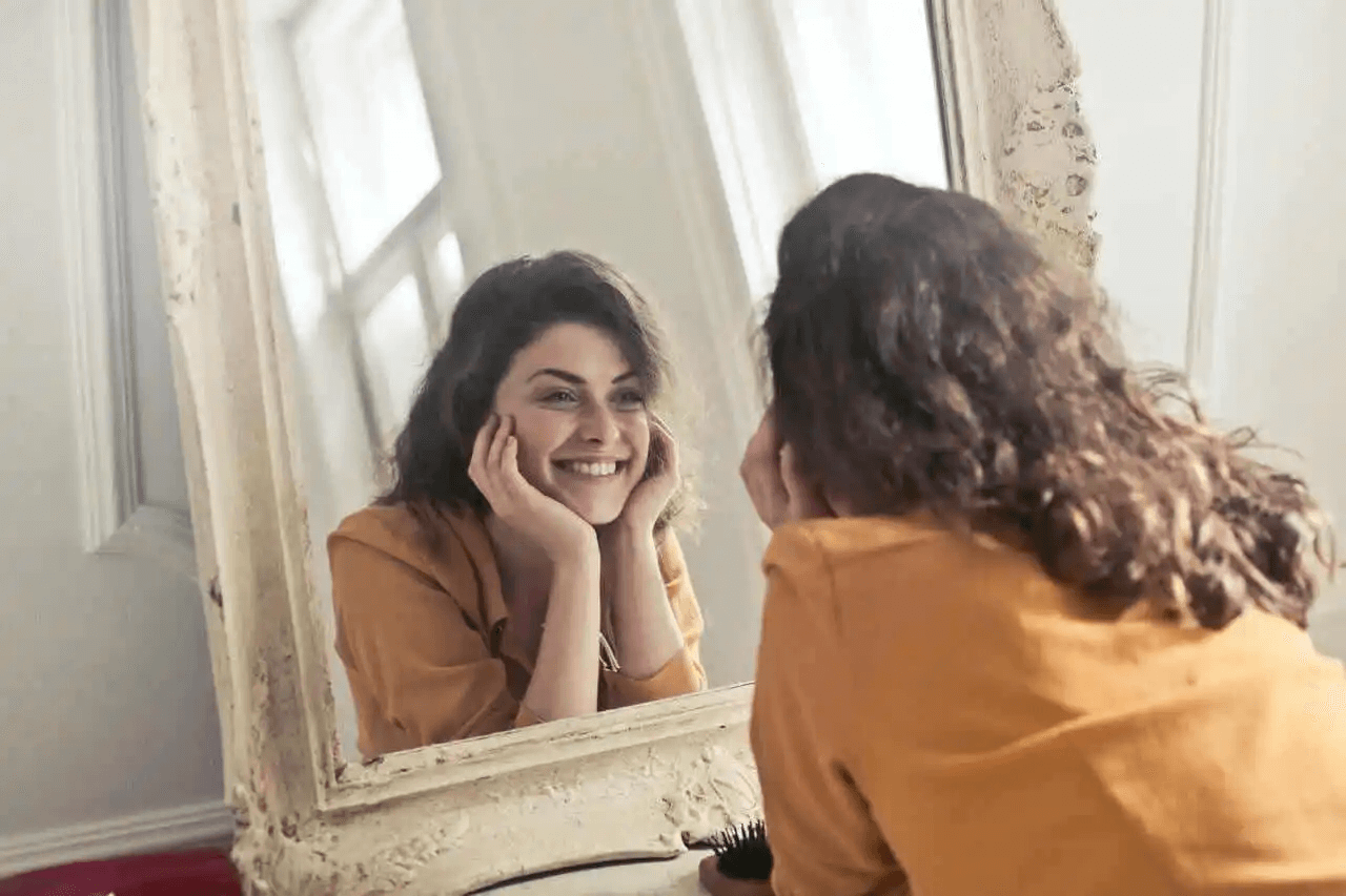kvinna ser sig själv i spegeln