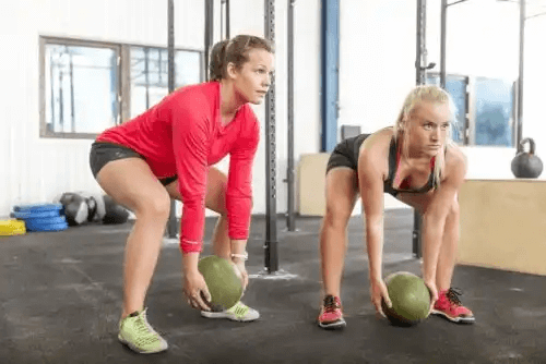 personer tränar med medicinbollar
