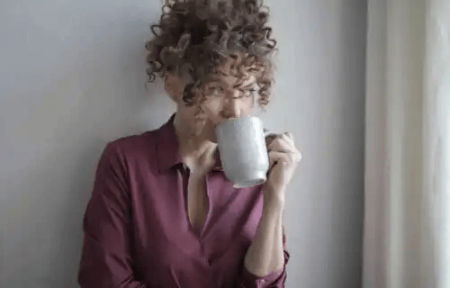 kvinna dricker från mugg
