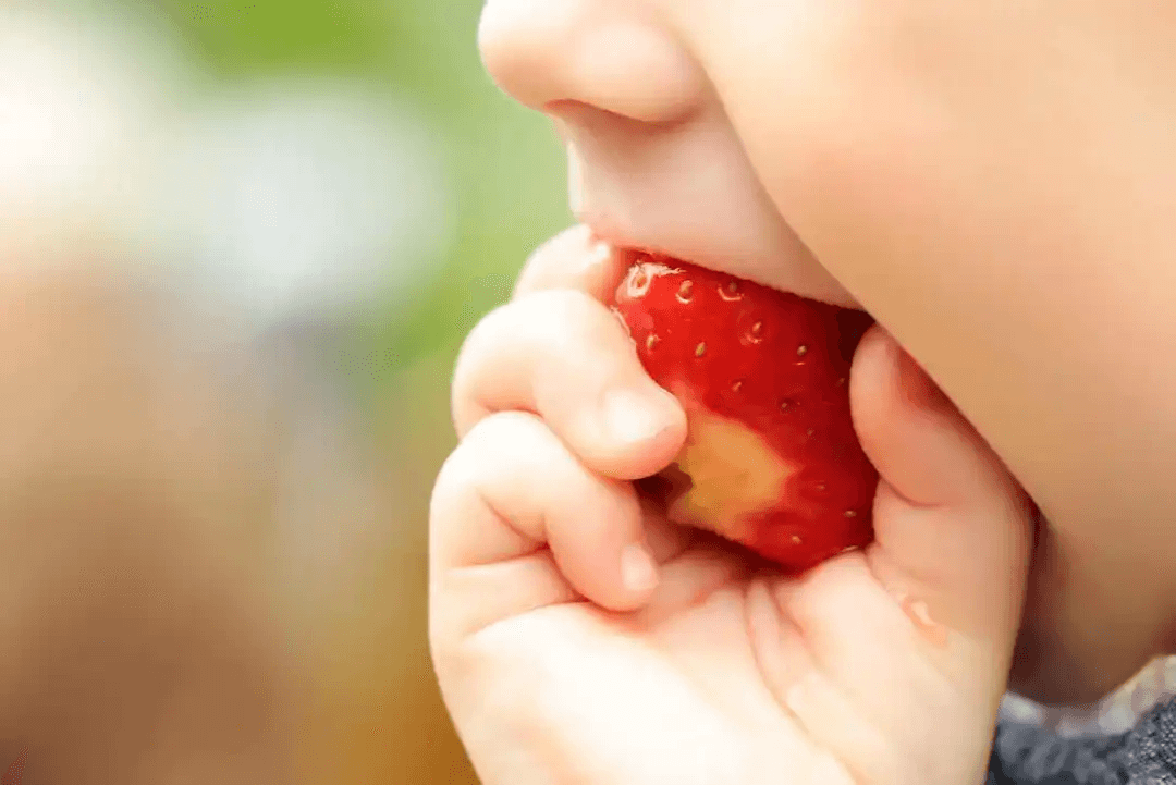 barn äter jordgubbe