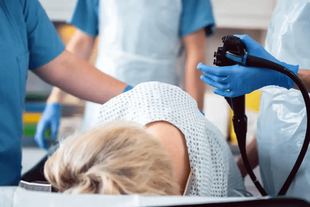 läkare knyter av en hemorrojd med ett gummiband på kvinna