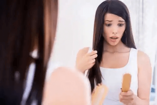 kvinna tittar förfärat på sin borste